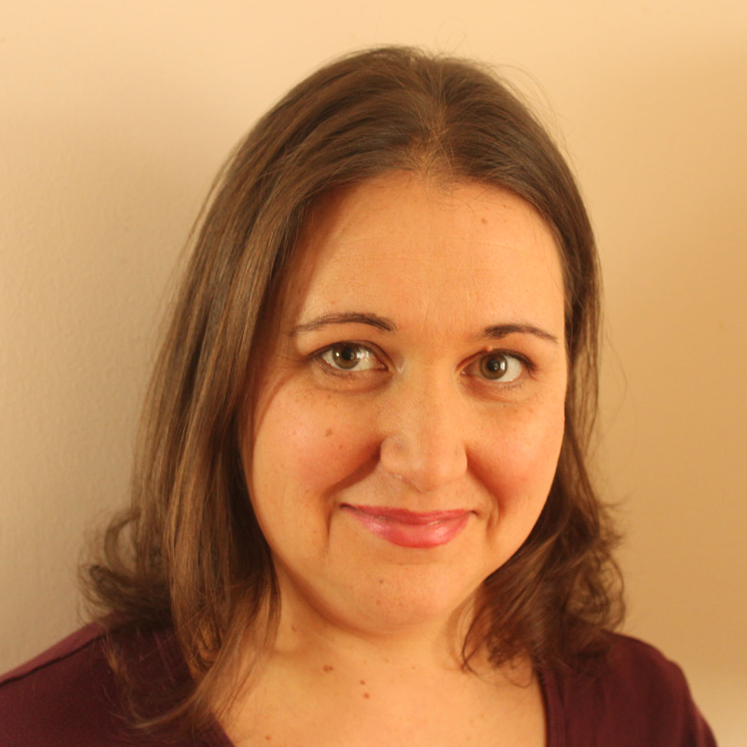 Headshot showing a smiling brunette woman.
